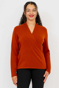 Front view of woman wearing a rust-colored surplice cashmere sweater