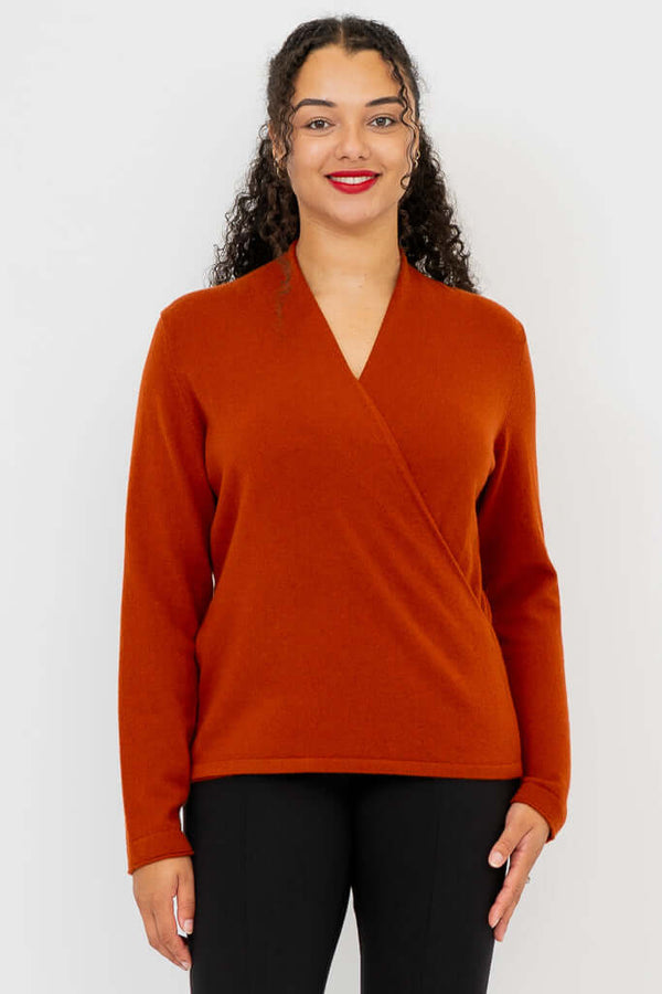 Front view of woman wearing a rust-colored surplice cashmere sweater