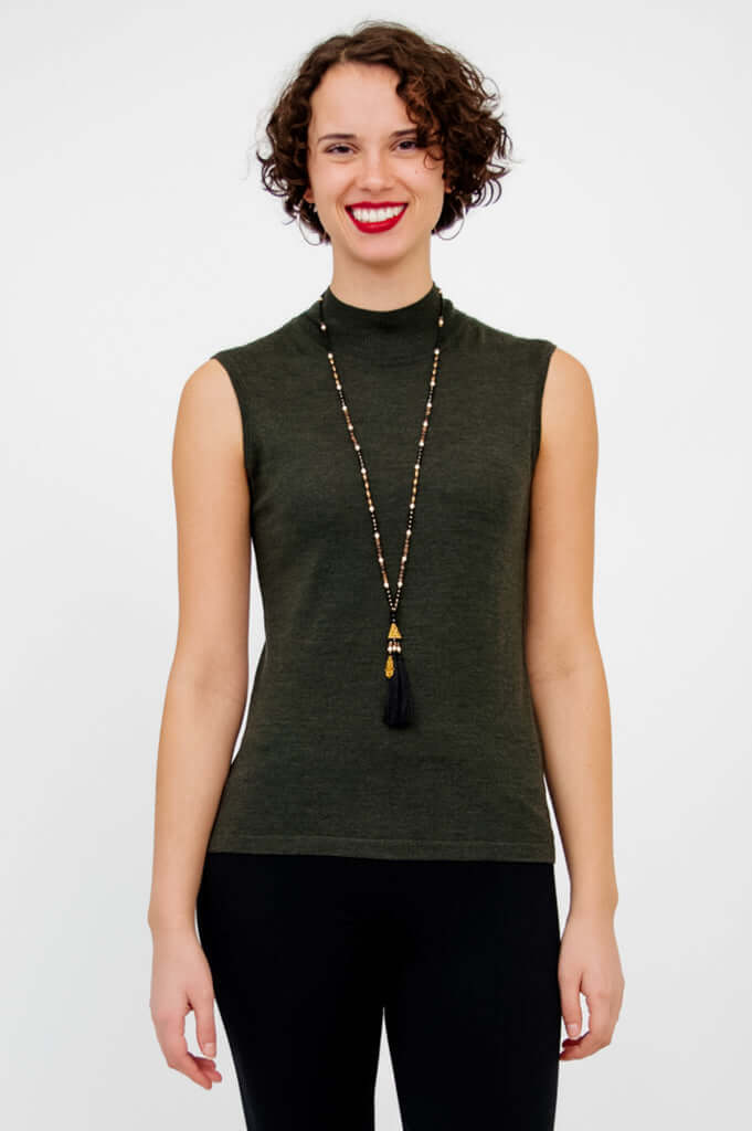 Front view of model wearing the sleeveless Rita Merino Wool Sweater in dark green