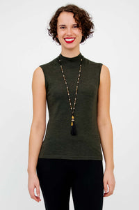 Front view of model wearing the sleeveless Rita Merino Wool Sweater in dark green