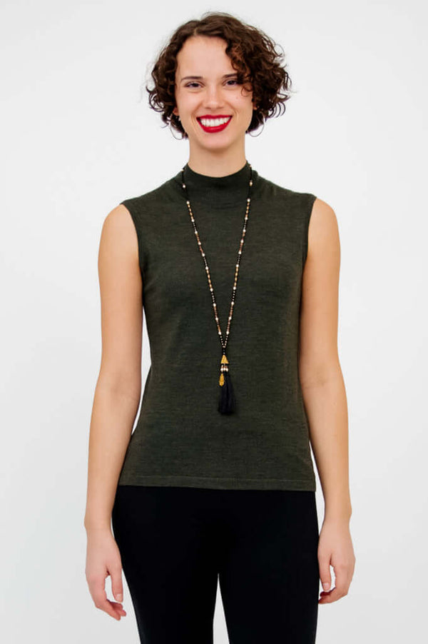 Front view of model wearing the sleeveless Rita Merino Wool Sweater in dark green