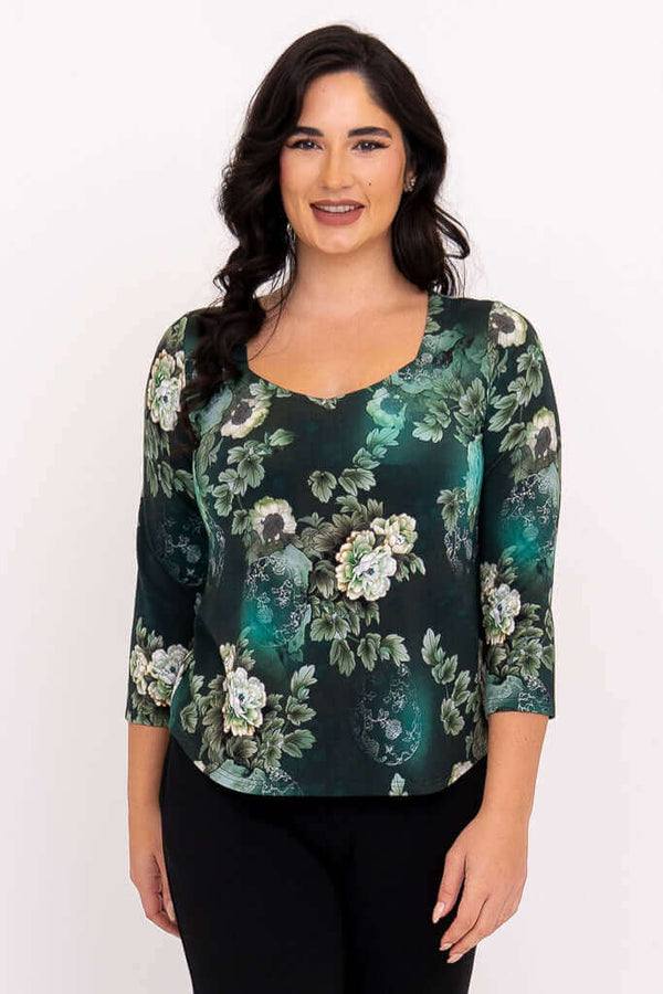 Front view of model wearing a dark green floral sweetheart neckline top with 3/4 sleeves