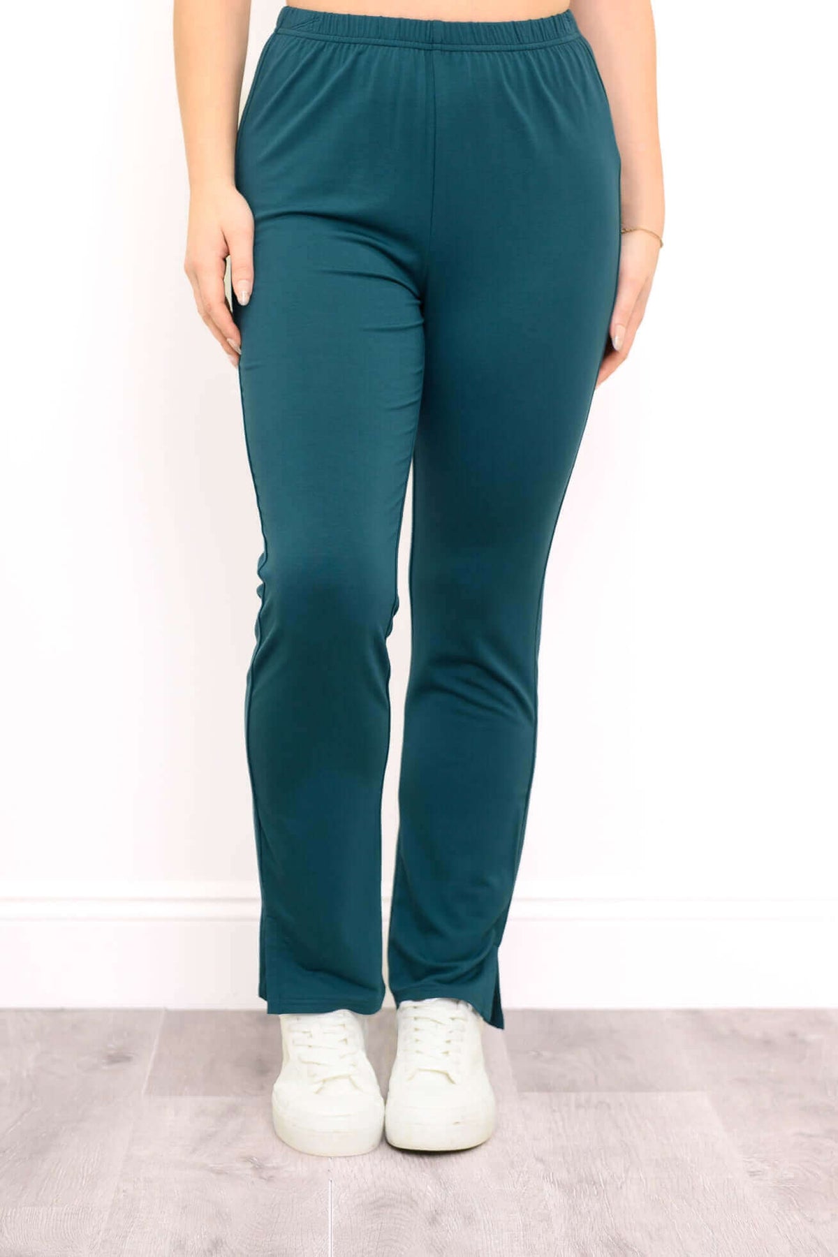 Front view of Sarina Pant in teal, styled with white sneakers