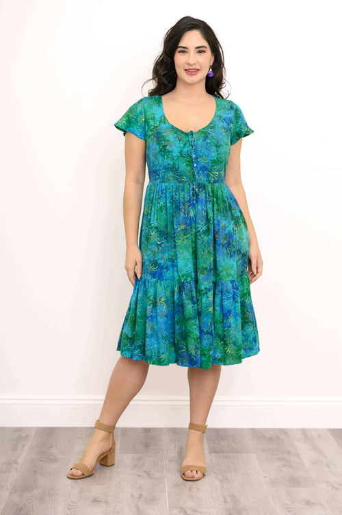 Front view of woman wearing a green and blue short sleeve tiered midi dress with buttons