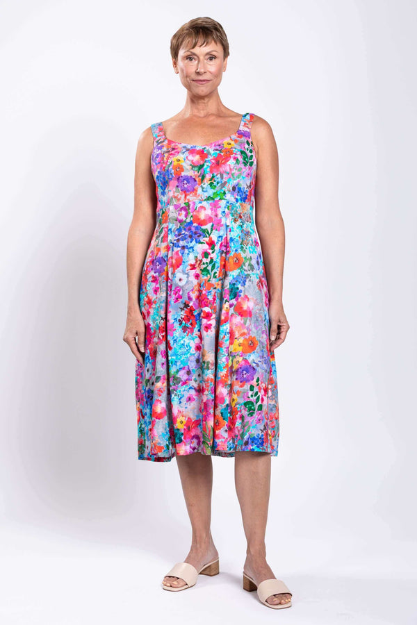 Front view of model wearing a vibrant floral A-line dress with wide straps