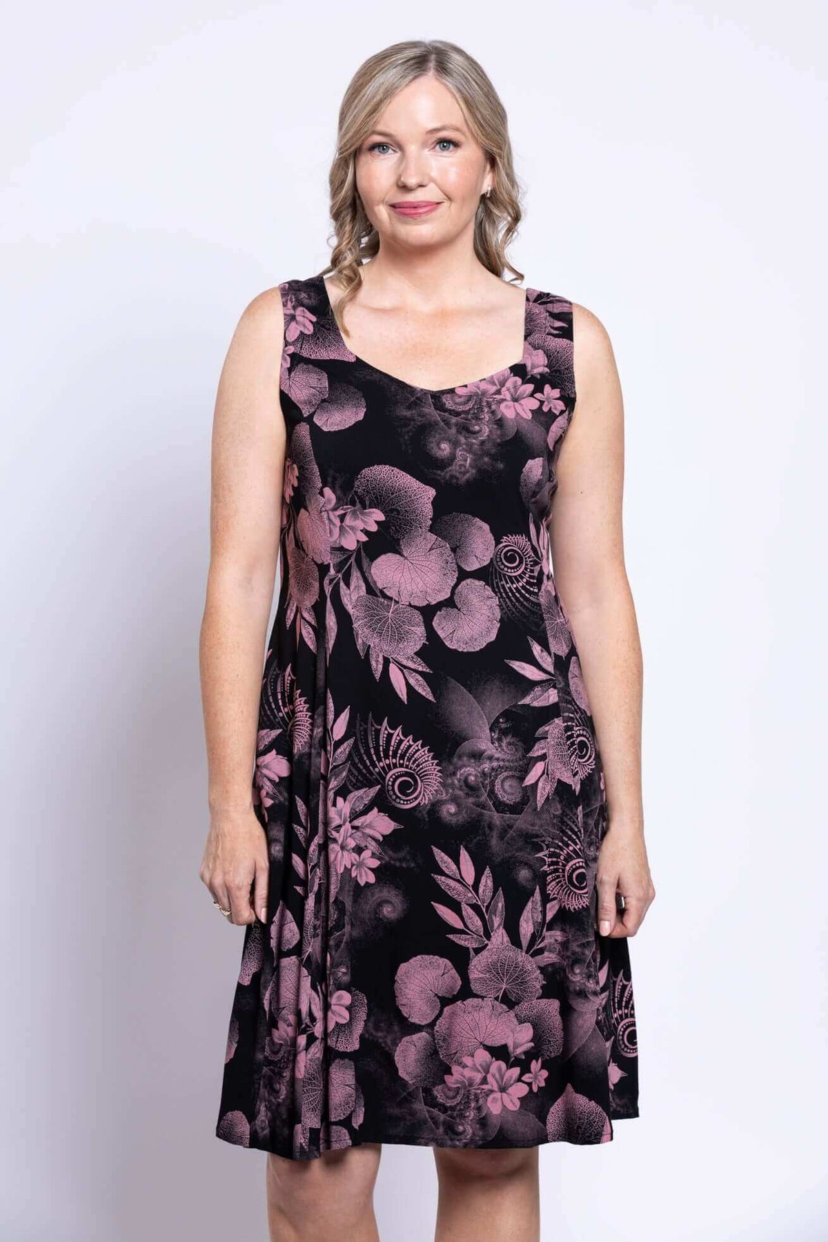 Front view of woman wearing Sweet Sara sleeveless dress in pink botanica print