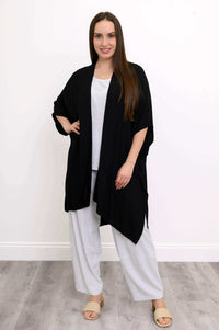 Front view of woman wearing a black Darcy kimono wrap over white outfit