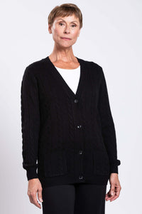 Front view of a woman wearing a black cable knit cardigan with pockets