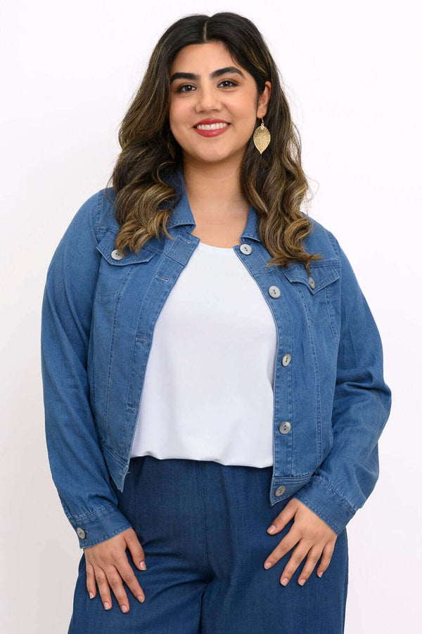 Front view of a woman wearing a classic blue denim jacket over a white top