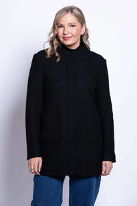 Front view of woman wearing a black boiled wool coat with mandarin collar