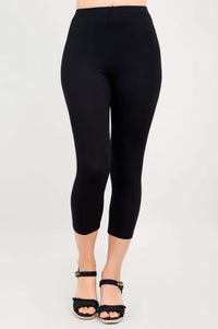 Front view of a person wearing black capri leggings with sandals
