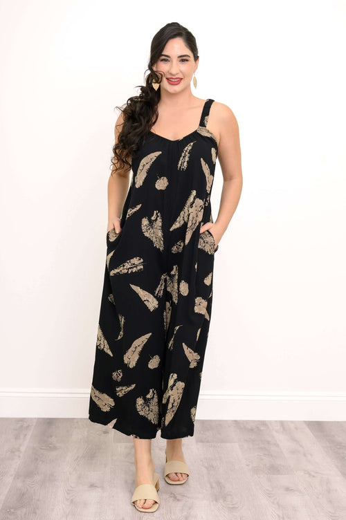 Woman wearing a black wide-leg jumpsuit with tan feather print, standing and facing forward