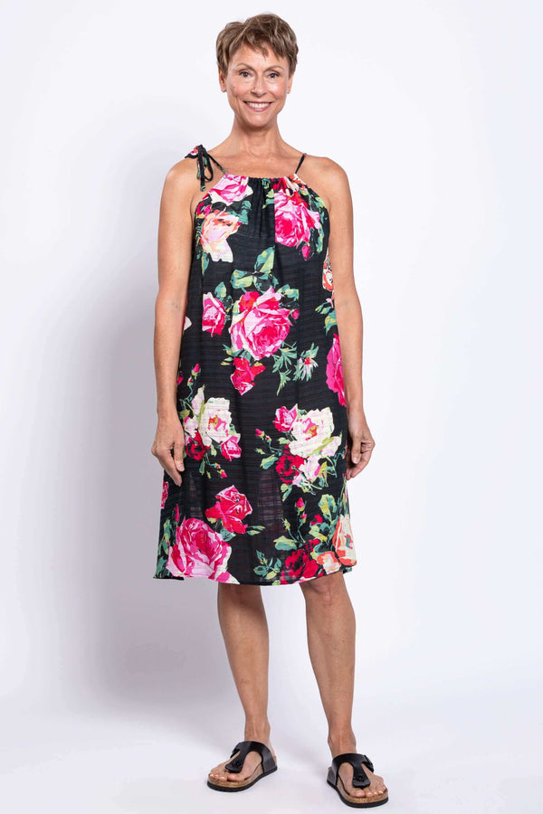 Front view of woman wearing black sleeveless floral beach dress with tie shoulder