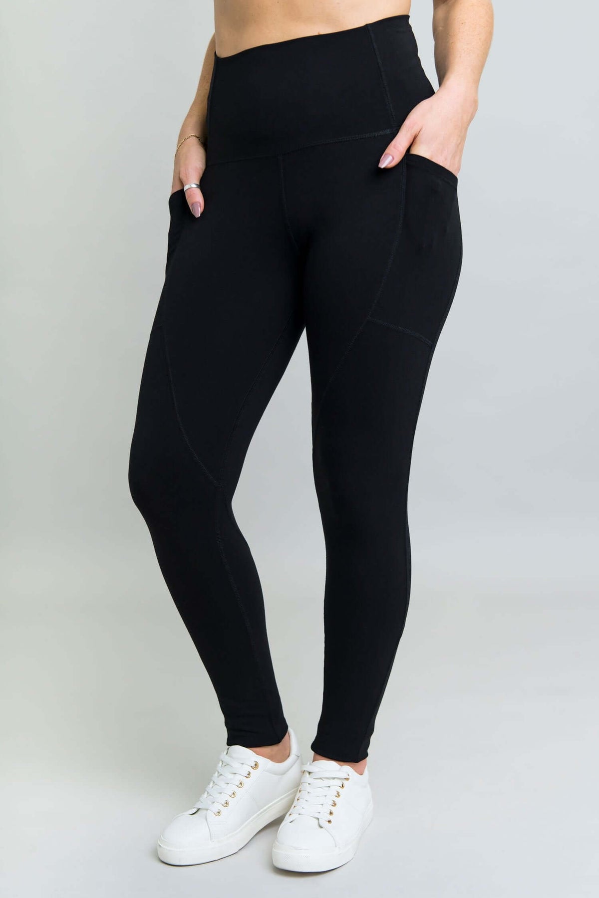 Front view of woman wearing black petite fleece leggings with side pockets