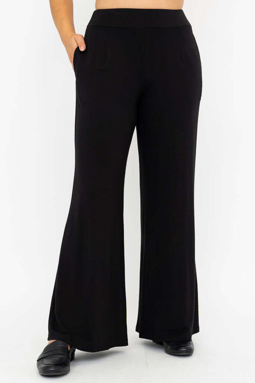 Front view of model wearing black wide leg pants with pockets
