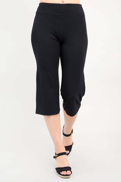 Front view of a woman wearing black yoga capri pants and black heeled sandals