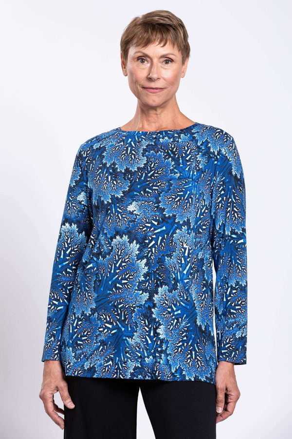 Front view of woman wearing a blue botanical print long top with boat neck