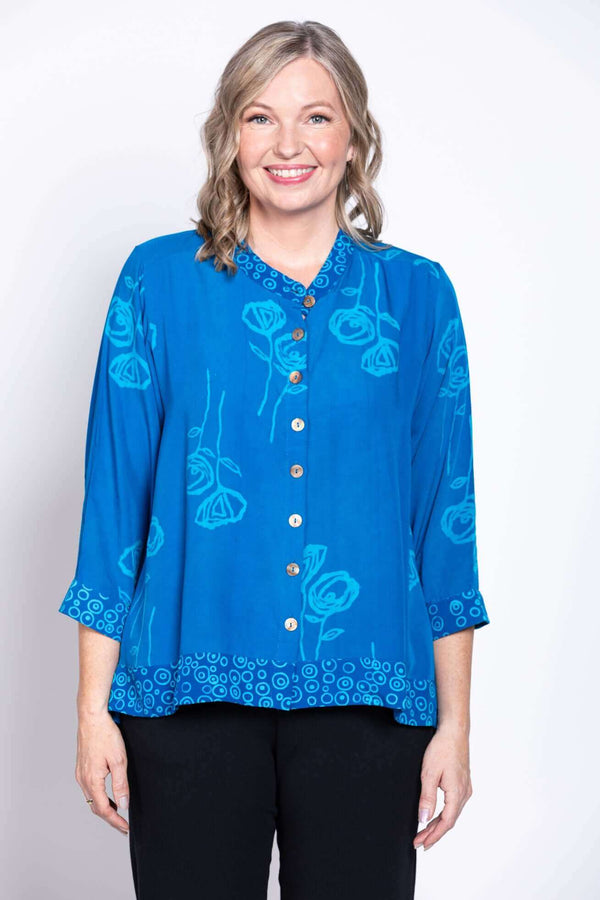 Front view of a woman wearing a blue floral cropped blouse with mandarin collar and button up design