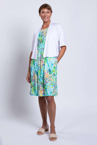 Front view of blue floral ruched dress with white cardigan and pockets