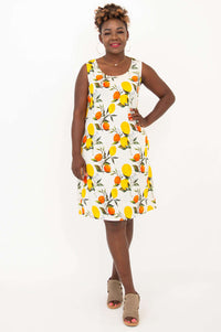 Front view of woman wearing a sleeveless shift dress with lemon and orange print
