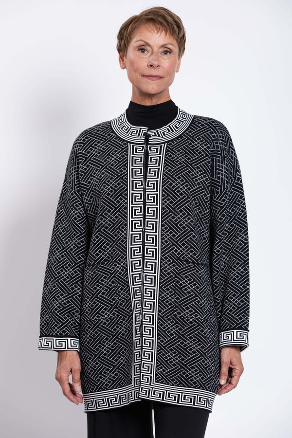 Front view of model wearing a black and white geometric knit cardigan with mandarin collar