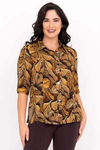 Front view of model wearing a golden leaf print blouse with elbow-length sleeves