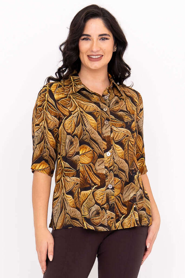 Front view of model wearing a golden leaf print blouse with elbow-length sleeves
