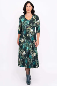 Front view of a woman wearing a jade green floral midi dress with empire waist