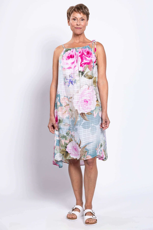Woman wearing a sleeveless floral beach dress with adjustable shoulder tie, front view