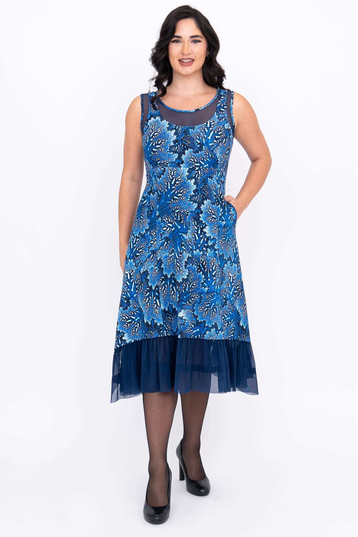 Front view of woman in blue sleeveless dress with mesh neckline and hem