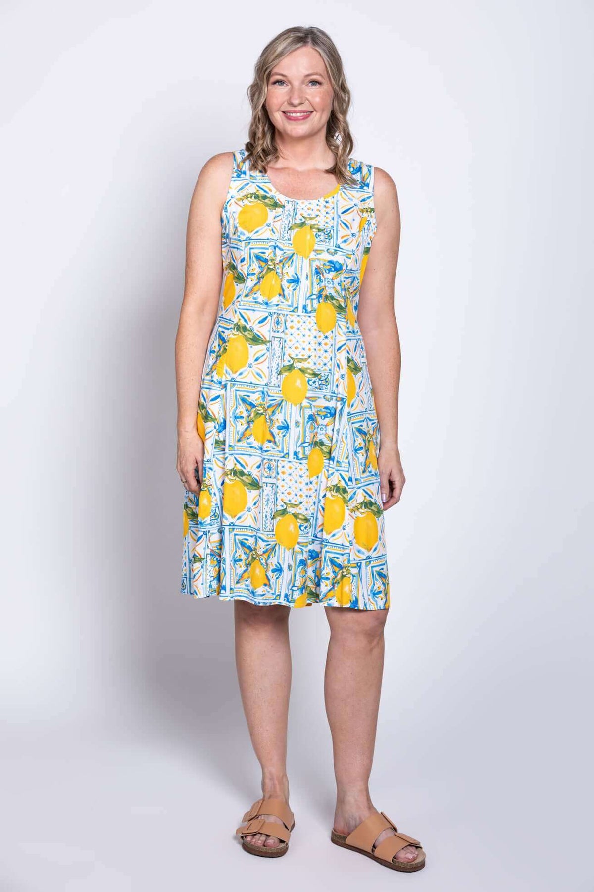 Model wearing sleeveless Arden dress with blue and yellow lemon tile print, front view