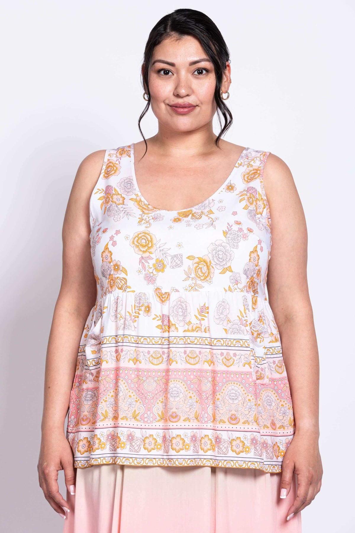 Front view of model wearing white and peach floral tiered tank top