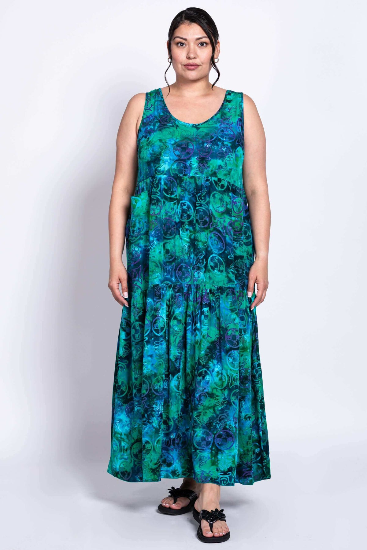 Front view of model wearing the Kayana dress in vibrant blue-green pattern
