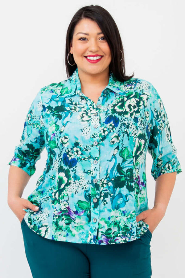 Front view of model wearing a blue and green floral bamboo-linen blouse