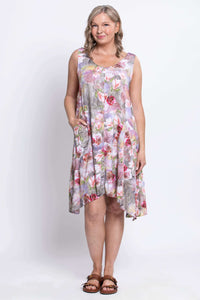 Front view of model wearing sleeveless floral Gia Dress with asymmetrical hem and pockets