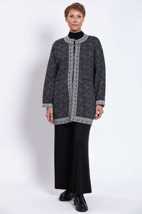 Front view of model in open front geometric knit cardigan with bold white trim