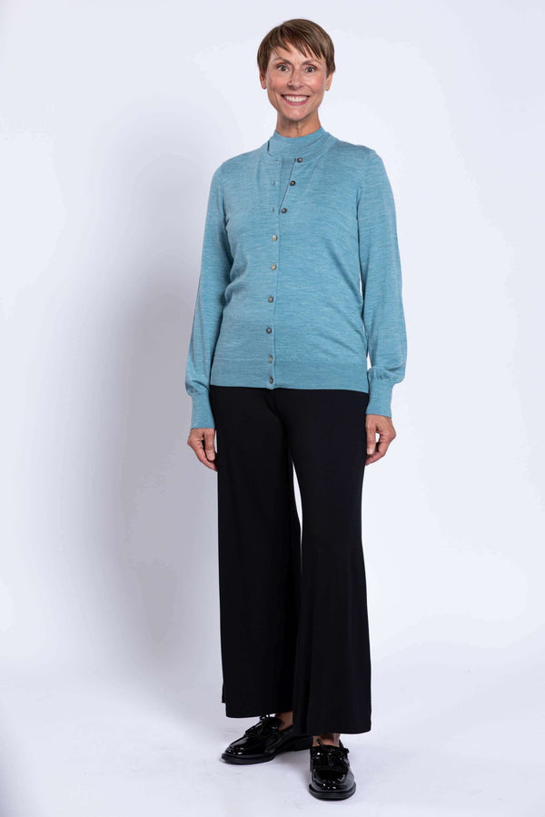 Front view of older woman in blue Kitten Cardigan and black wide-leg pants