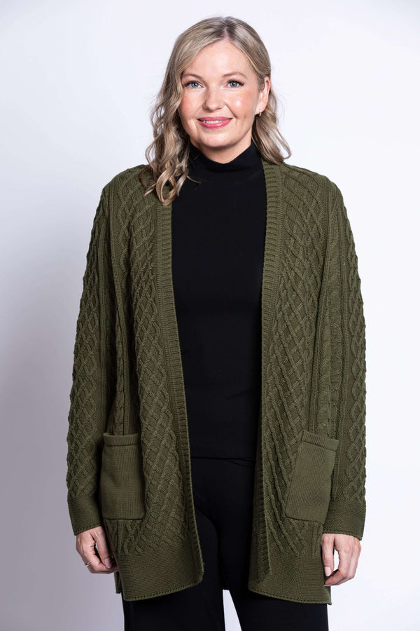Front view of woman wearing olive green cable knit cardigan with patch pockets