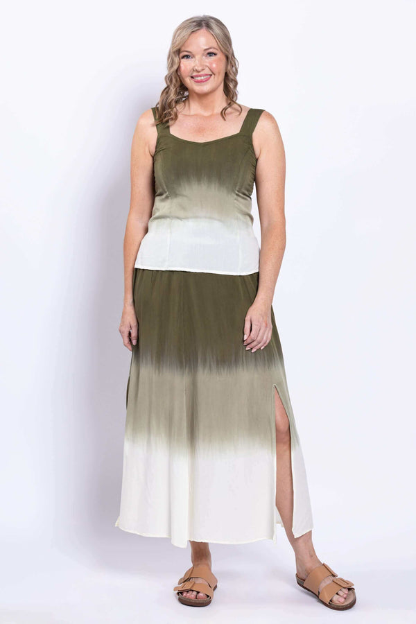 Front view of a woman wearing an olive ombre maxi skirt with side slit.