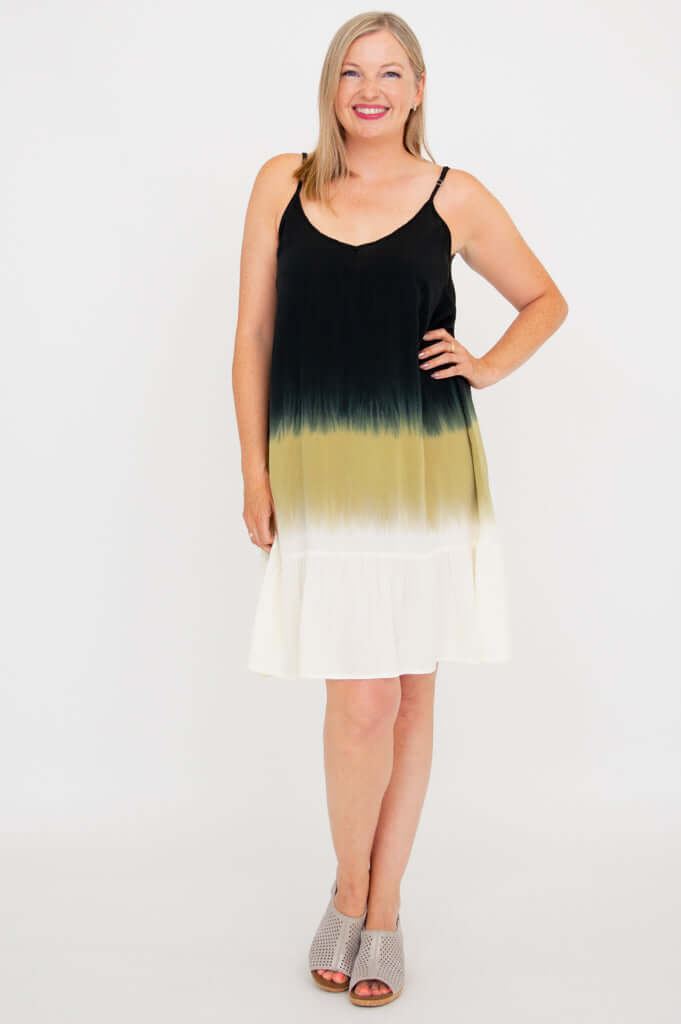 Front view of woman wearing an ombre black, olive, and white tiered dress