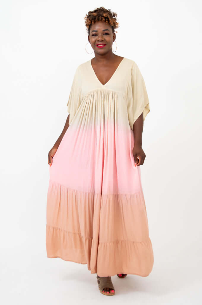 Front view of model wearing a beige to peach ombre tiered maxi dress