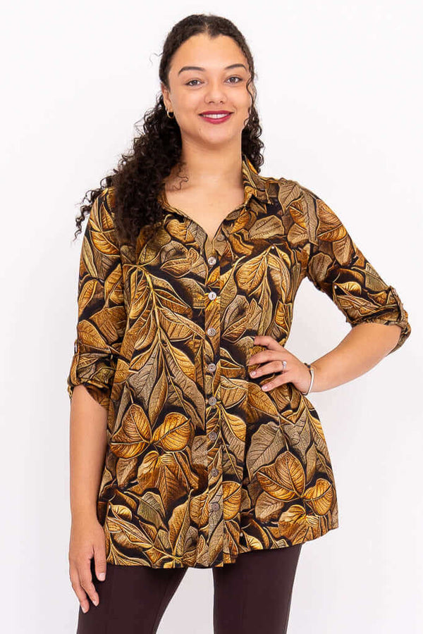 Front view of a model wearing an oversized bamboo linen tunic with brown leaf print