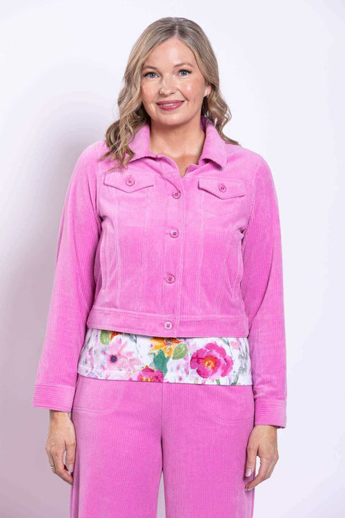 Front view of woman wearing pink corduroy jacket and floral top