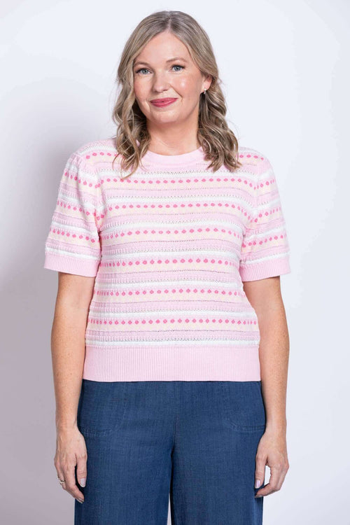 Front view of woman wearing pink short sleeve dot knit sweater