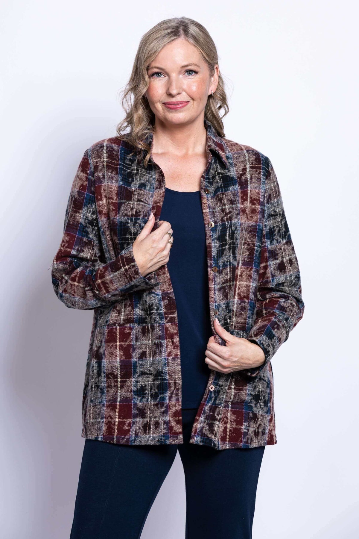 Front view of a woman wearing a plaid cotton jacket over a navy top