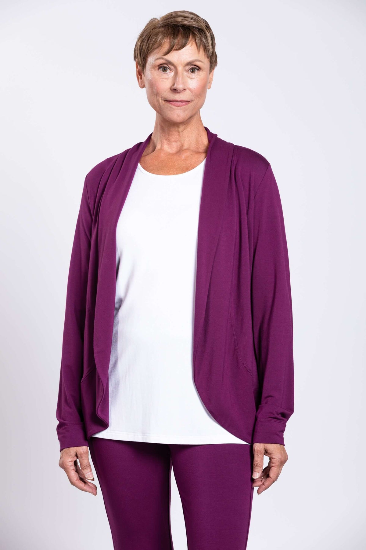 Front view of a woman wearing a plum bamboo French terry jacket over a white top