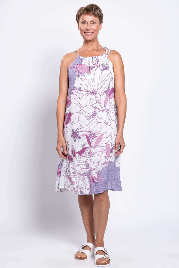 Front view of a woman modeling a purple and white floral beach dress with adjustable tie