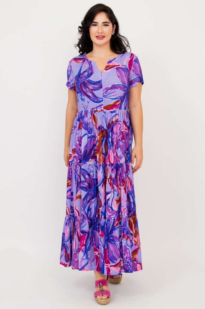 Front view of woman in a purple multicolor floral maxi dress with a relaxed fit and short sleeves