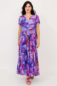 Front view of woman in a purple multicolor floral maxi dress with a relaxed fit and short sleeves
