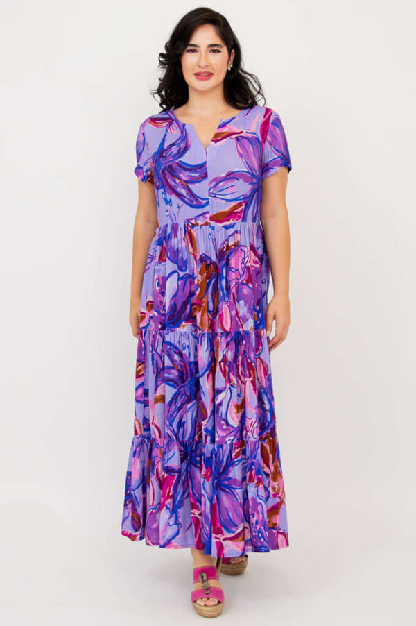 Front view of woman in a purple multicolor floral maxi dress with a relaxed fit and short sleeves